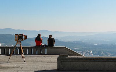 Couple sitting on a wall overlooking Viana do Castelo, Portugal. Unsplash:Nicolas Armoa