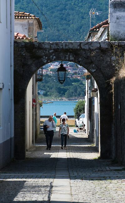 People walking through an archway in Caminha, Portugal. Unsplash:Desert Morocco Adventure