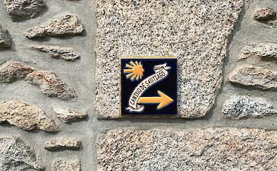 Sign on a wall for the Camino de Santiago, Spain. Unsplash:Max Kukurudziak