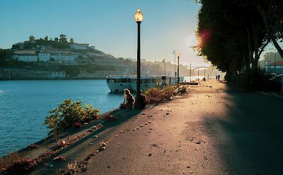 Sitting beside the river at sunset, Porto, Portugal. Unsplash:Augusto Lopes