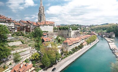The turquoise Aare River flows beside the historic cityscape of Bern, Switzerland. Unsplash@Will Truettner