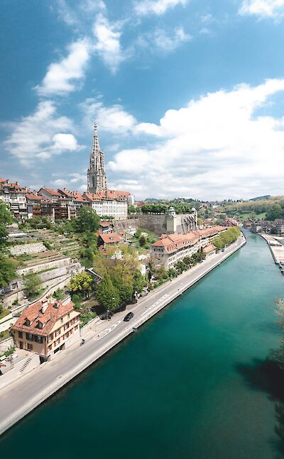 The turquoise Aare River flows beside the historic cityscape of Bern, Switzerland. Unsplash@Will Truettner