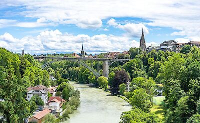 View of the Aare River flowing beneath a large arched bridge in Bern, Switzerland. Unsplash@Alin Andersen