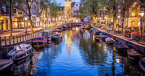 Canals and boats in Amsterdam, North Holland, the Netherlands. Photo via Flickr:Sergey Galyonkin