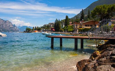 A wooden pier on the blue water of Lake Garda, Italy. Unsplash@Louis Tripp