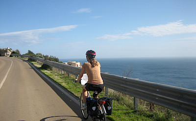 Gea cycling along the coast in Puglia, Italy.