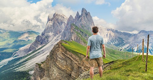 Man standing looking at mountain peaks. Unsplash@Joshua Earle