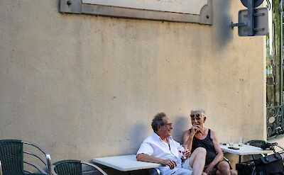 Couple sitting outside a hotel in Arles, France. Unsplash:Pier Francesco Grizi