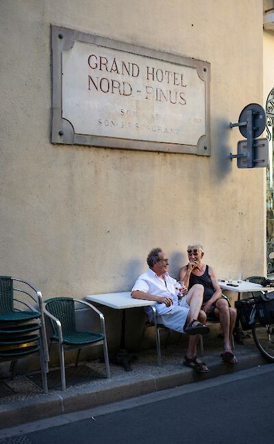 Couple sitting outside a hotel in Arles, France. Unsplash:Pier Francesco Grizi