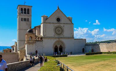 The Basilica of Saint Francis of Assisi in Umbria under blue skies. Unsplash@Mattia Poli