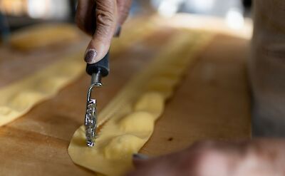 Cutting out pasta shapes. Unsplash@Lorenzo Tomasetti