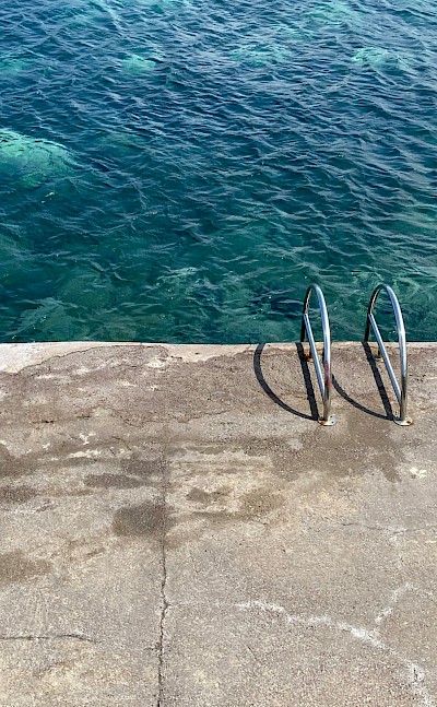 Ladder into the ocean, Salina, Italy. Unsplash@Emma Dickopf