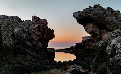 Sunset behind rocks in Milazzo, Italy. Unsplash@Giuseppe Famiani