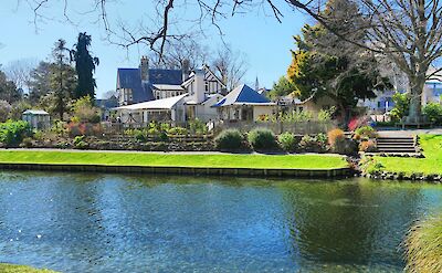 White house with blue roof across the river, Avon River, Christchurch, New Zealand. Brendan Pfahlert@Unsplash