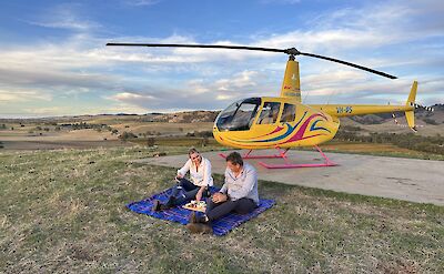 Couple enjoying the picnic in front of the helicopter, Barossa Valley, Australia. CC:Barossa Helicopters