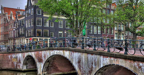 Bikes over the canal bridge in Amsterdam, North Holland, the Netherlands. Photo via Flickr:vgm8383