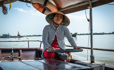 Woman driving a boat on the Mekong Delta, Vietnam. Unsplash:Lewis J Goetz