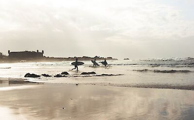 Surfers in Matosinhos, Portugal. Unsplash: Alvara Polo