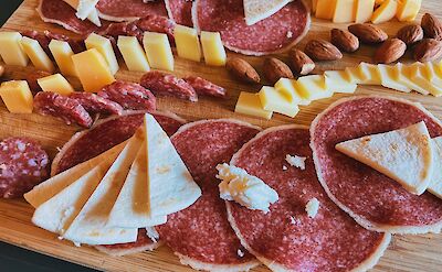 Slices of meat cheese and nuts on a chacuterie board, Lisbon, Portugal. Unsplash: Frank Zhang