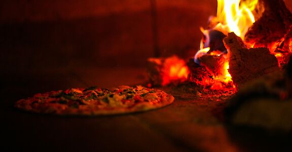 Wood fired Pizza in the oven, New York, USA. Unsplash: Hemant Latawa
