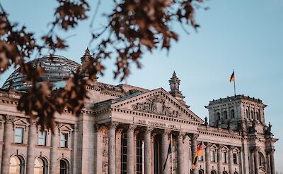 Reichstag from behind trees, Berlin, Germany. Unsplash: Yannic Kreß