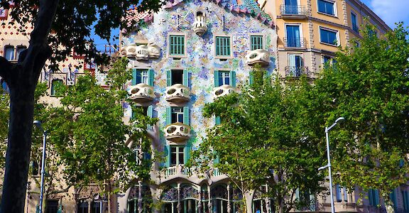 Trees fronting a beautiful building, Casa Batllo, Barcelona, Spain. Unsplash: Ruggiero Calabrese