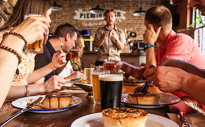 Eating pies with beer in Soho, London, England.CC: Eating Europe