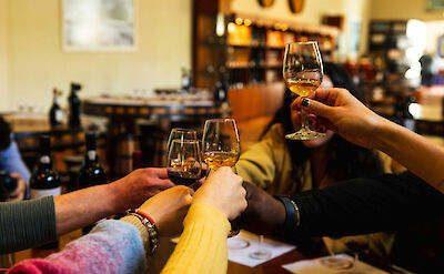 Clinking wine glasses in Porto, Portugal. CC: Eating Europe