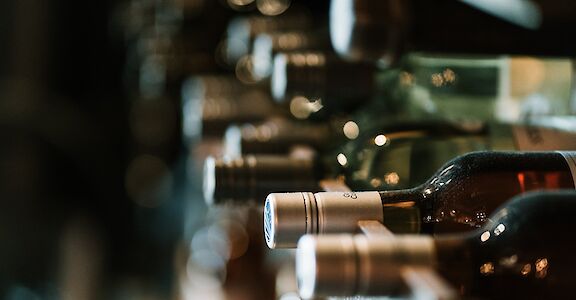 Bottles of wine in a wine cellar. Unsplash: Hermes Rivera