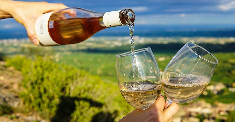 Pouring wine, France. Unsplash: Elle Hughes