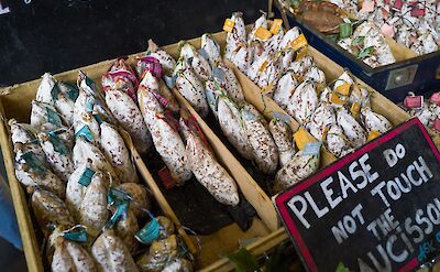 Market stall with salami. Unsplash: George Iermann