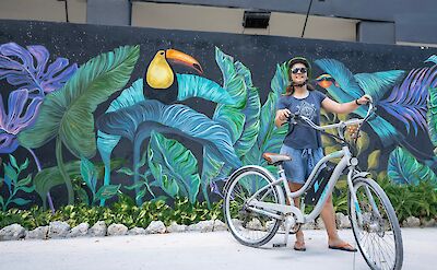 Standing next to a mural, Tulum, Mexico. CC:Mexico Kan Tours