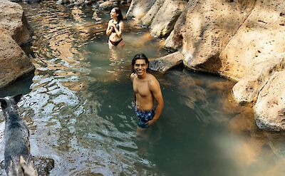 Two people smiling at a waterfall. Frank Flores@Unsplash