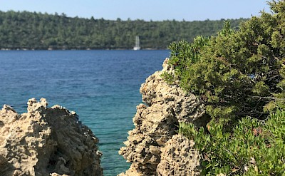 View of a boat through rocks, Bodrum, Turkey. Unsplash@Maupie