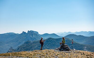 Hikers taking in panoramic mountain views. toST
