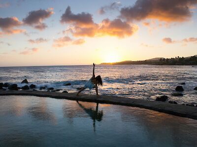 Doing yoga at sunset by the ocean on a corporate retreat. Kristopher Allison@Unsplash