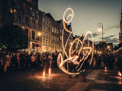 Watching a street performance at night on a company retreat. Dawid Zawila@Unsplash