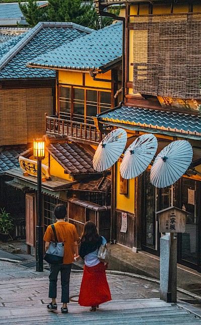Traditional wooden buildings with paper lanterns and parasols. Unsplash@Romeo