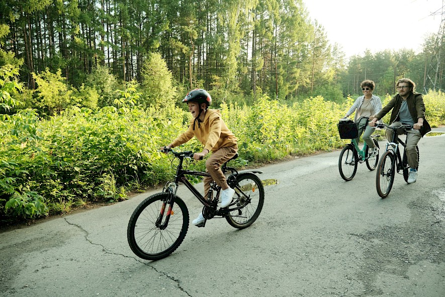 A boy having fun riding a bike on a family bike vacation. Unsplash@Getty Images
