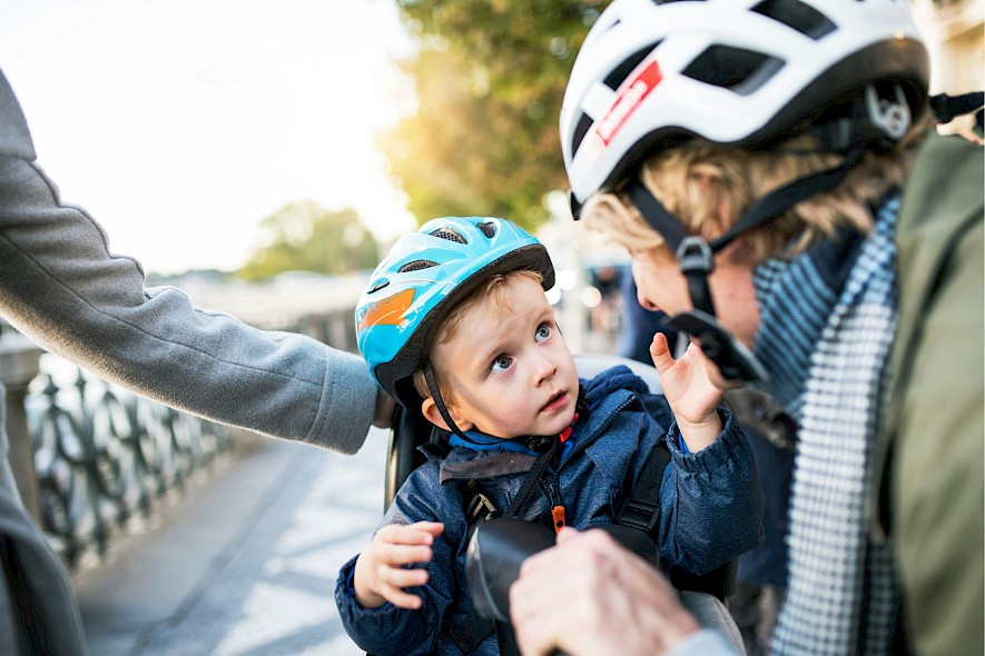 A toddler looking at his grandma on a family bike trip. Unsplash@Getty Images