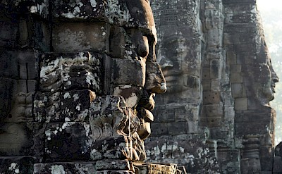 Faces on the temples at Angkor Wat, Cambodia bike tour. Unsplash@Wei Gao