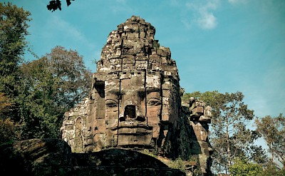 Large face on the temple at Angkor Wat, Cambodia bike tour. Unsplash@Chanmana Sayny
