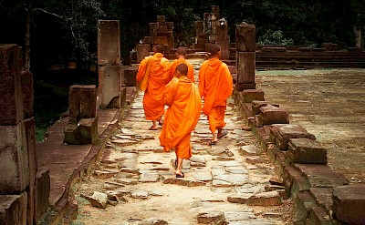 Monks on the pathways of Angkor Wat, Cambodia bike tour. Unsplash@Sergio Capuzzimati