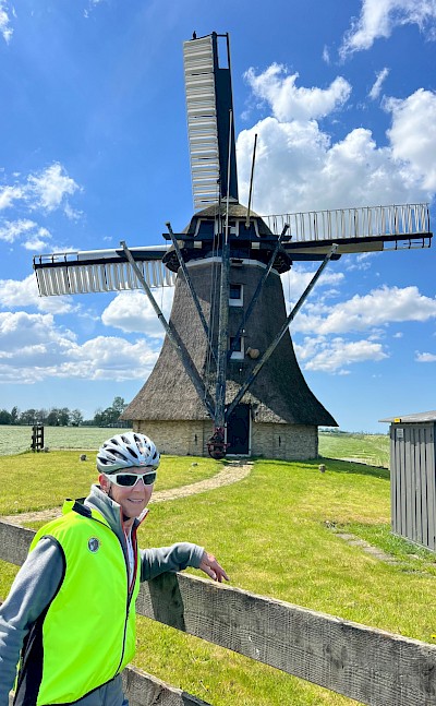 Cycling past an iconic Dutch windmill on tour. ©Hennie