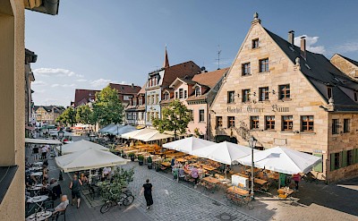 Market Square with cafés, shops, and colorful outdoor stalls. unsplash@tourist information