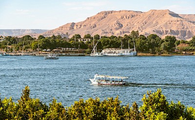 Traditional feluccas and cruise boats sailing the Nile near Luxor. unsplash@Sean Wang
