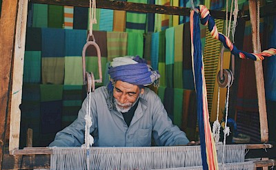 A traditional weaver at work on a handloom. unsplash@rawanyasser