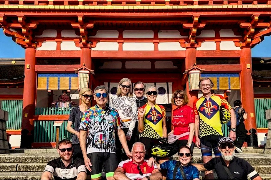 Bike tour group in front of a historic gate, Japan.