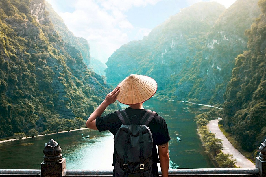 Man admiring the view in a conical hat. Unsplash@Giau Tran