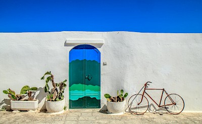 Bright white walls and colorful doors in Ostuni. pexels@Edocoledoco